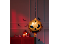 Χρυσό μπαλόνι κολοκύθας Halloween κρεμασμένο σε δωμάτιο με κόκκινο φως.