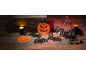 Διακοσμήσεις Halloween με κολοκύθες, νυχτερίδες, κεριά και ένα μπουκάλι σε ξύλινο τραπέζι.