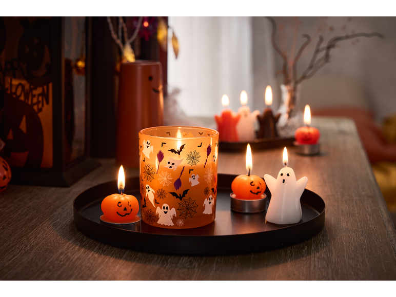 Κεριά Halloween σε σχήμα φαντασμάτων και κολοκύθων σε δίσκο, με την επιγραφή «Happy Halloween» στο παρασκήνιο.