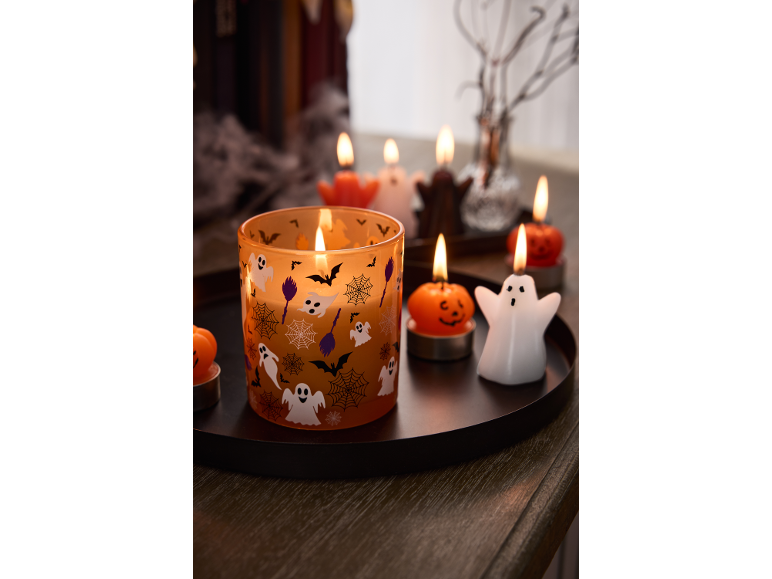 Κεριά και ρεσό με θέμα το Halloween σε σκούρο δίσκο, με φαντάσματα, κολοκύθες και νυχτερίδες.