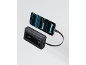 Μαύρο power bank φορτίζει ένα smartphone με φωτεινή μπλε οθόνη