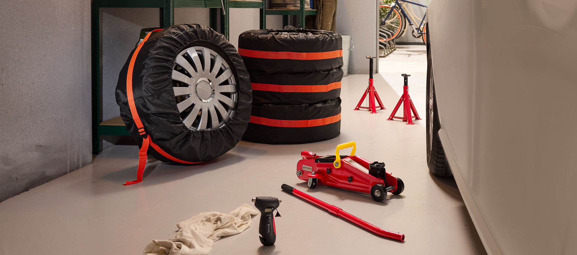 Ελαστικά αυτοκινήτου με καλύμματα, γρύλος και βάσεις σε γκαράζ.