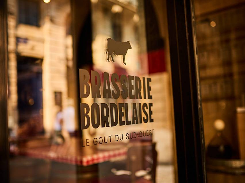 Πινακίδα Brasserie Bordelaise με σιλουέτα αγελάδας και το κείμενο «Le Goût du Sud-Ouest».