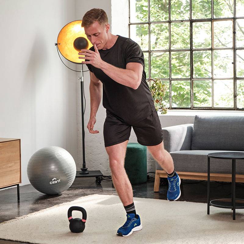 Άνδρας προπονείται με ιατρική μπάλα Crivit, kettlebell και μπάλα γυμναστικής