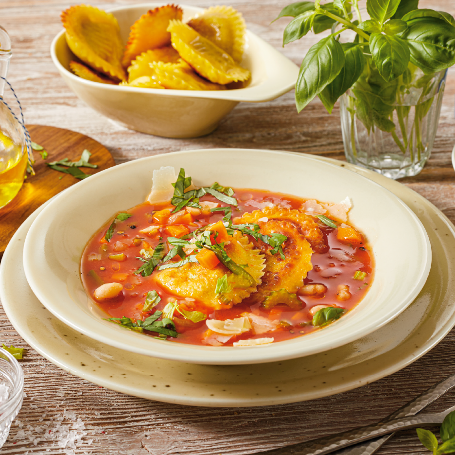 Ραβιόλια σε σάλτσα ντομάτας με λαχανικά, παρμεζάνα και βασιλικό, με τηγανητά ραβιόλια στο βάθος.