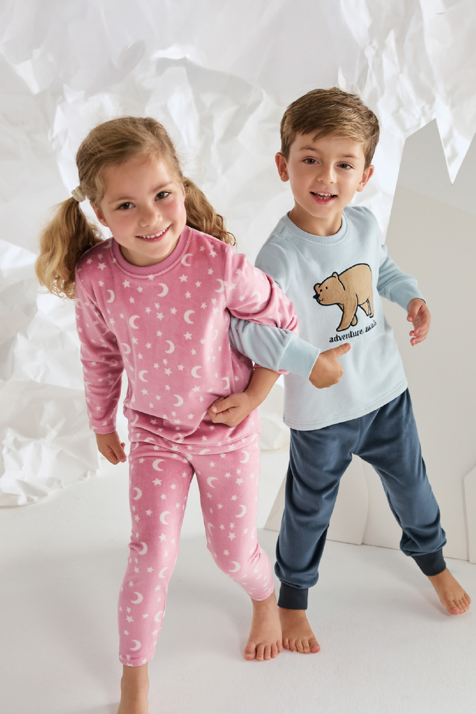 Παιδικές πιτζάμες με σχέδια φεγγαριών και αστεριών σε ροζ και αρκούδας σε γαλάζιο.