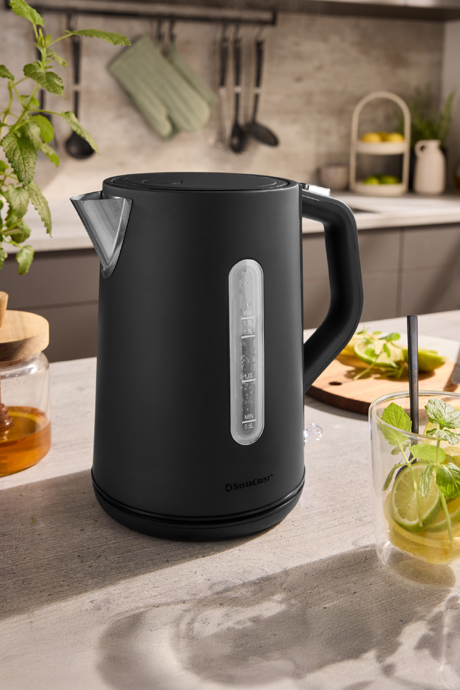 Μαύρος βραστήρας SilverCrest σε πάγκο κουζίνας με μέντα και λάιμ.