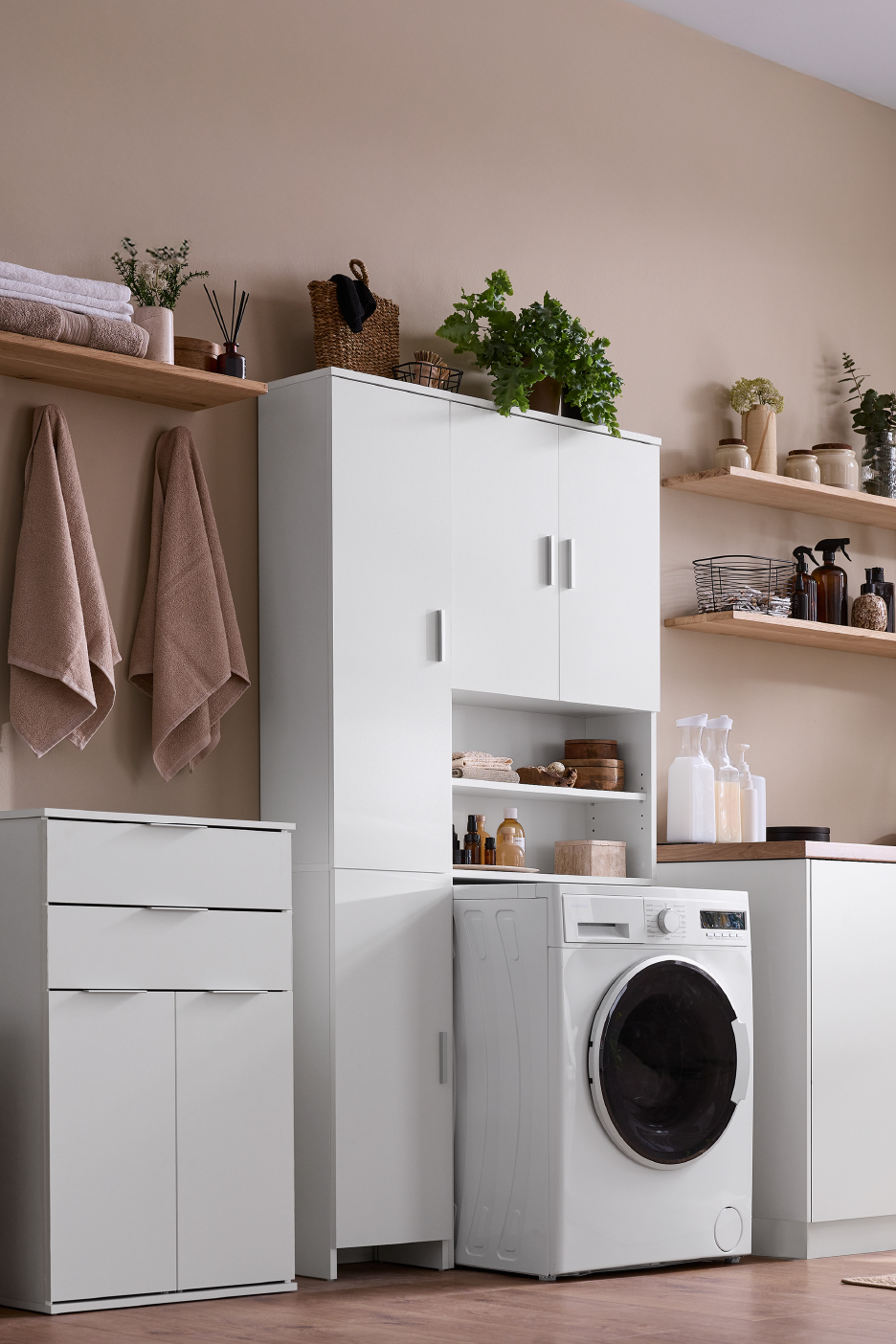 Πλυντήριο ρούχων σε ένα οργανωμένο δωμάτιο πλυντηρίων με λευκά ντουλάπια και ξύλινα ράφια.