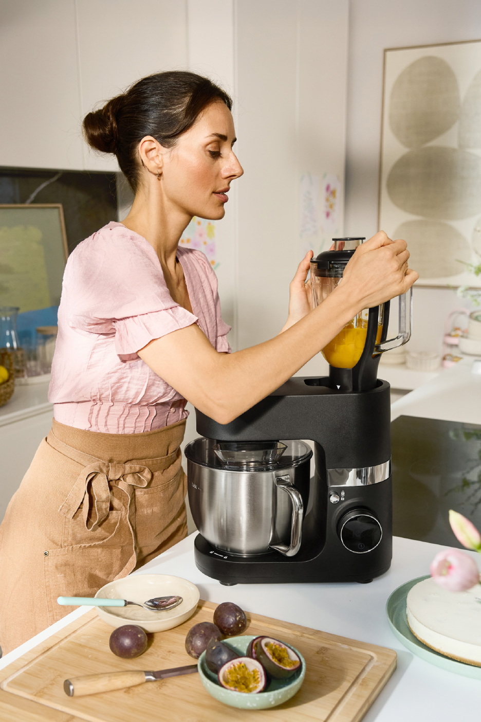 Γυναίκα χρησιμοποιεί μαύρο πολυμηχάνημα κουζίνας με μπλέντερ και ανοξείδωτο μπολ.