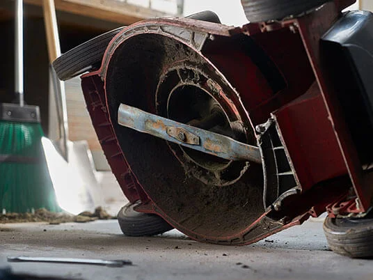 Βρώμικο χλοοκοπτικό ανάποδα, με ορατή λεπίδα