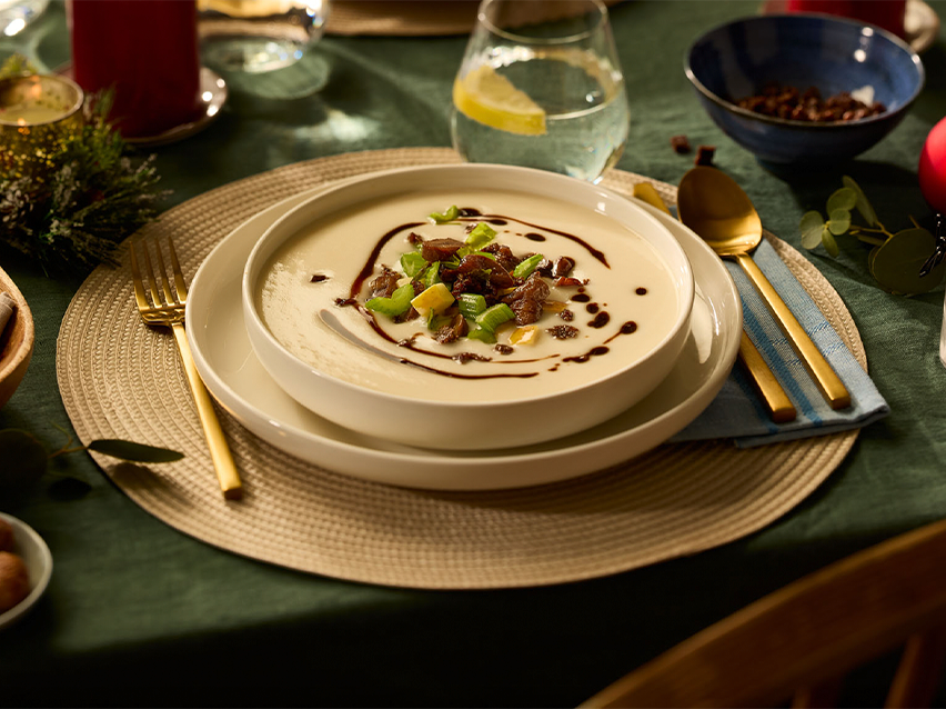 Κρεμώδης σούπα με κρέας και λαχανικά σε γιορτινό τραπέζι.