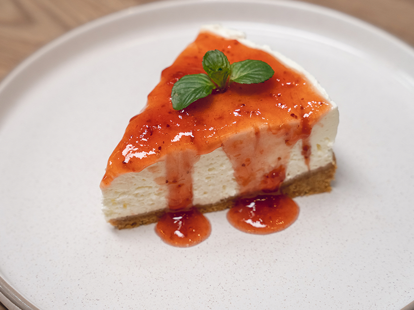 Μια φέτα τσιζκέικ με σάλτσα φράουλας.