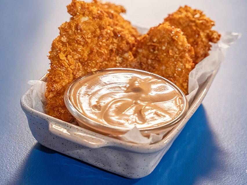 Τραγανές κοτομπουκιές με σάλτσα σε μπλε φόντο