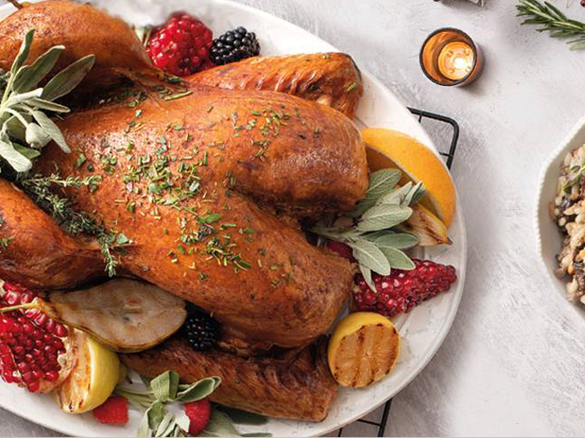 Χριστουγεννιάτικο γεύμα με ψητή γαλοπούλα, φρούτα και γαρνιτούρα.