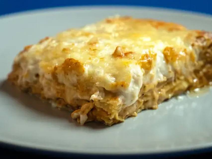 Λαζάνια με κρεμώδη σάλτσα και λιωμένο τυρί σε γκρι πιάτο.