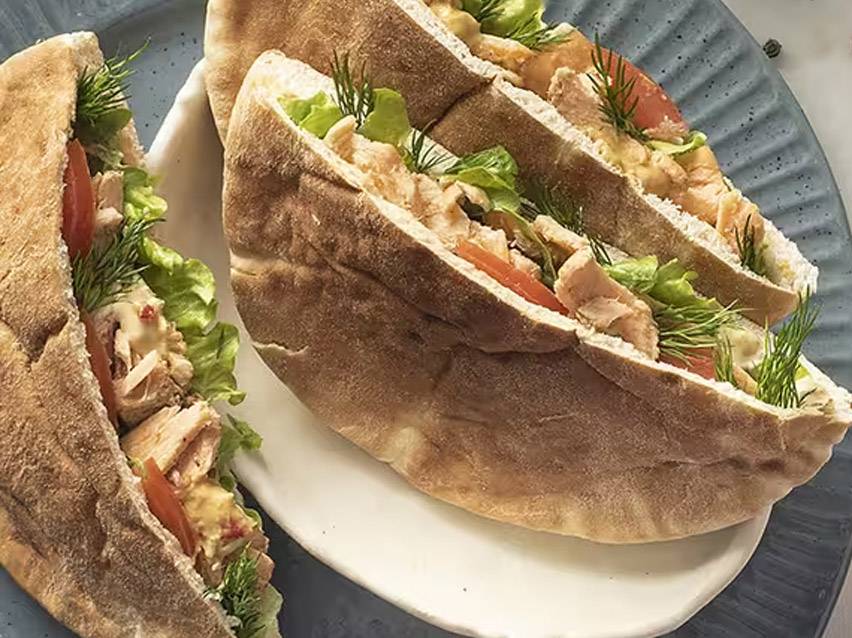 Πίτες με κοτόπουλο, μαρούλι, ντομάτα και άνηθο σε λευκό πιάτο.