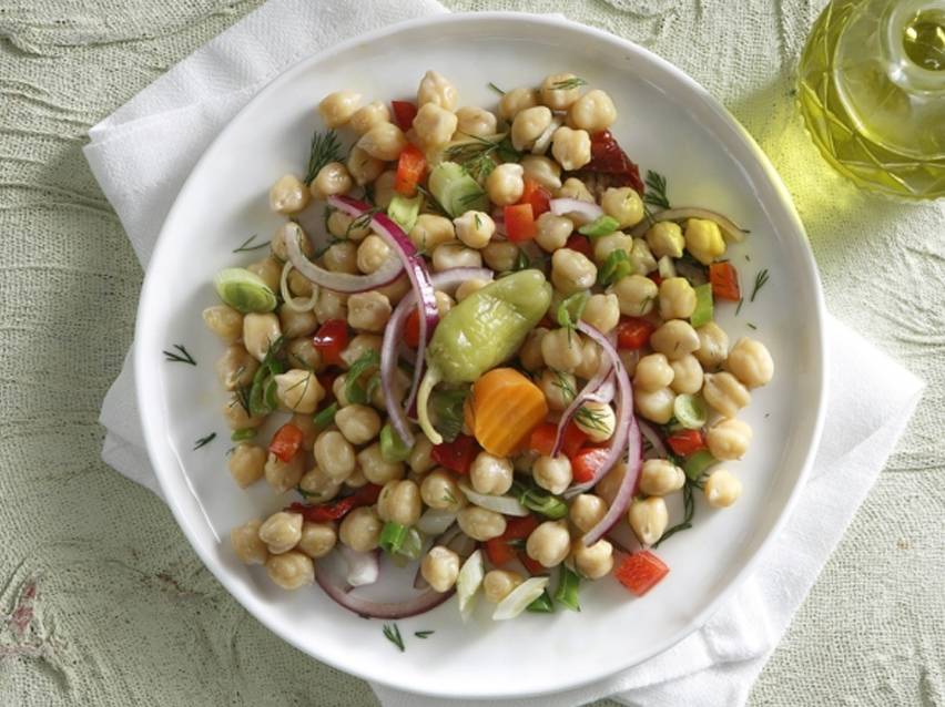 Σαλάτα ρεβιθιών με κόκκινο κρεμμύδι, πιπεριές και άνηθο σε λευκό πιάτο.