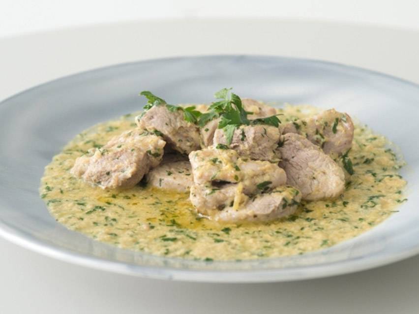 Χοιρινό με σάλτσα μουστάρδας και μαϊντανό σε γκρι πιάτο.