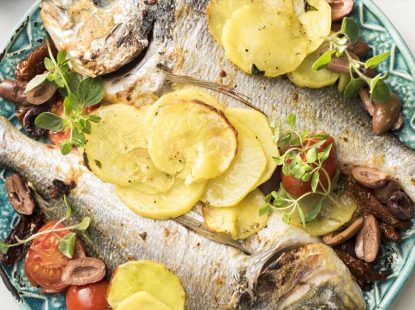 Ψητά ψάρια με πατάτες, ελιές και ντομάτες.