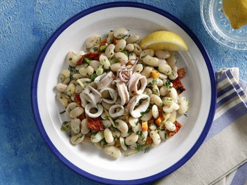 Σαλάτα με φασόλια, καλαμάρια, λιαστές ντομάτες και άνηθο, με μια φέτα λεμόνι.