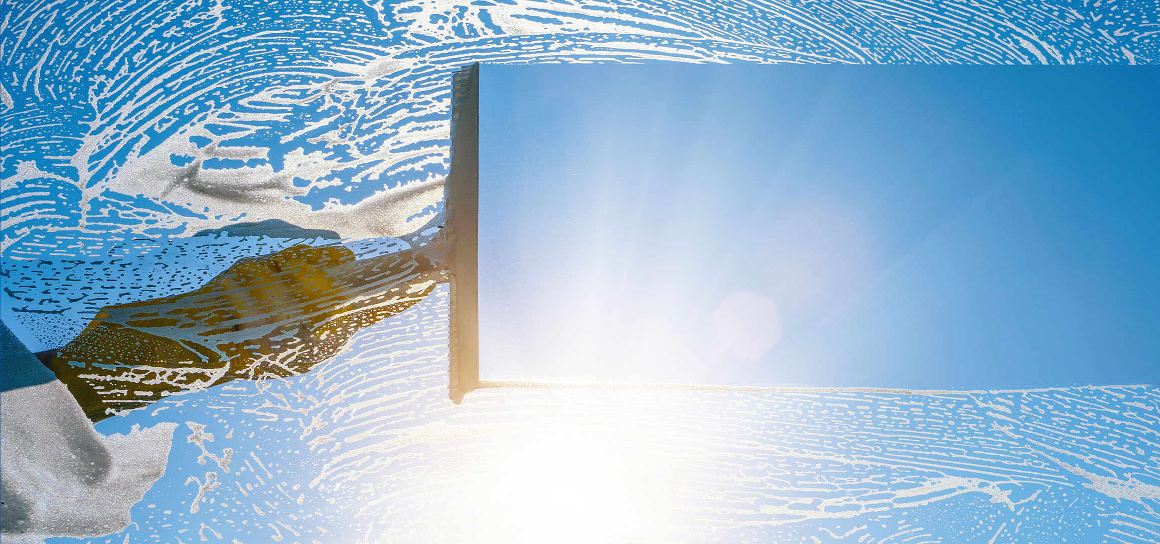 Καθαρισμός παραθύρων με σαπουνάδα σε γαλανό ουρανό.