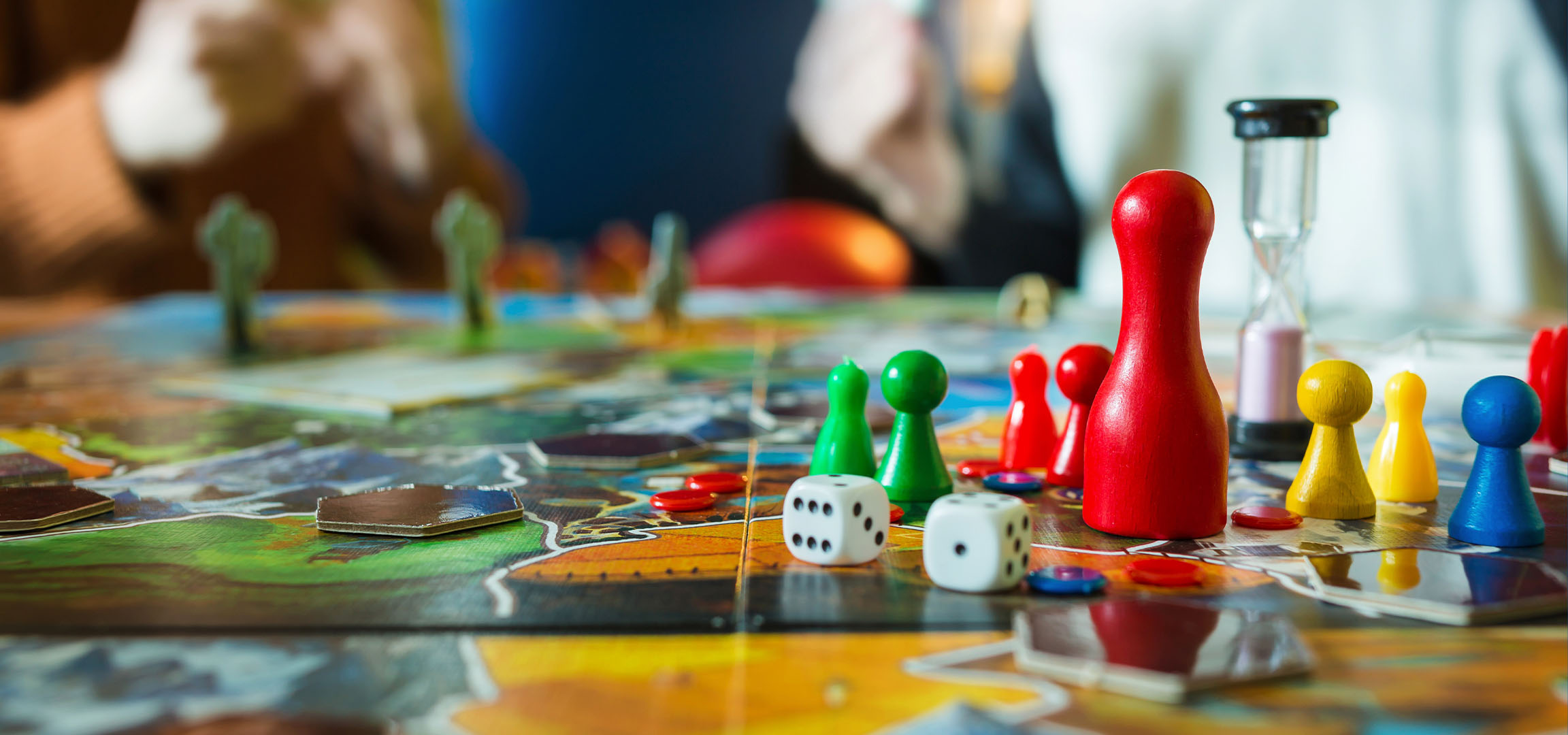 Πολύχρωμα πιόνια επιτραπέζιου παιχνιδιού, συμπεριλαμβανομένων κόκκινων, πράσινων, κίτρινων και μπλε, με ζάρια.