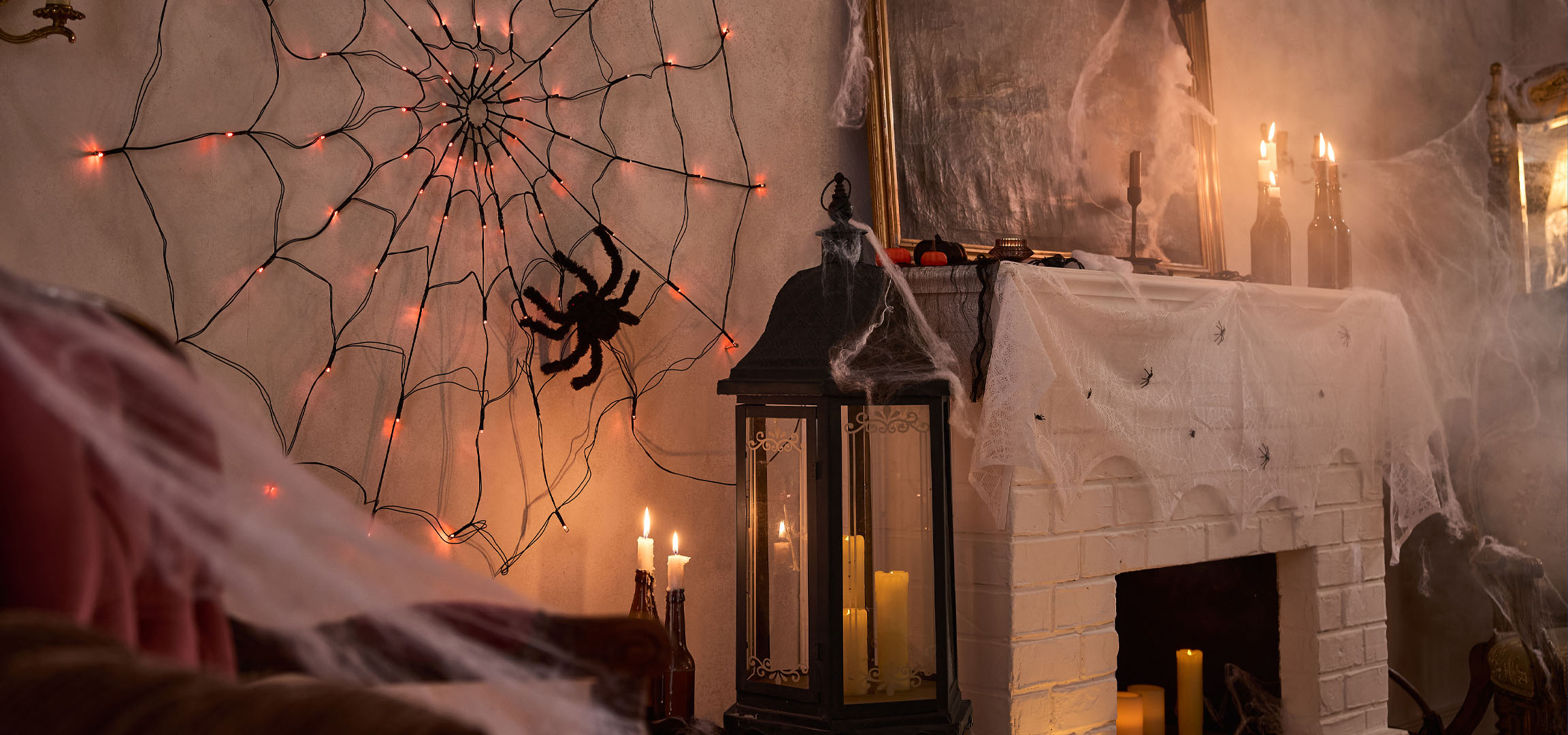 Διακοσμήσεις Halloween με φώτα ιστού αράχνης, μια μεγάλη αράχνη και κεριά.