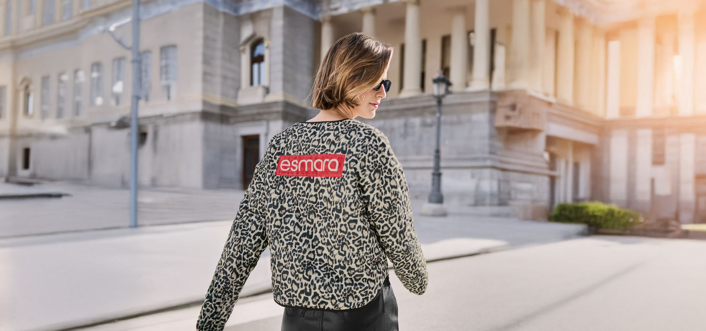 Γυναίκα με λεοπάρ ζακέτα Esmara, γυαλιά ηλίου, σε αστικό δρόμο.