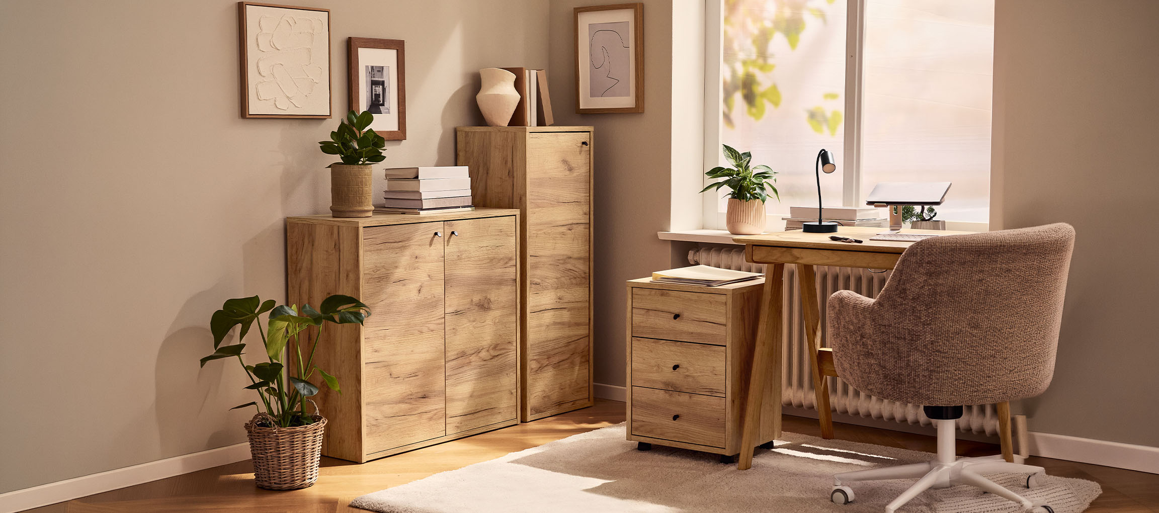 Οικιακό γραφείο με ξύλινα ντουλάπια, γραφείο και καρέκλα, διακοσμημένο με φυτά και πίνακες.