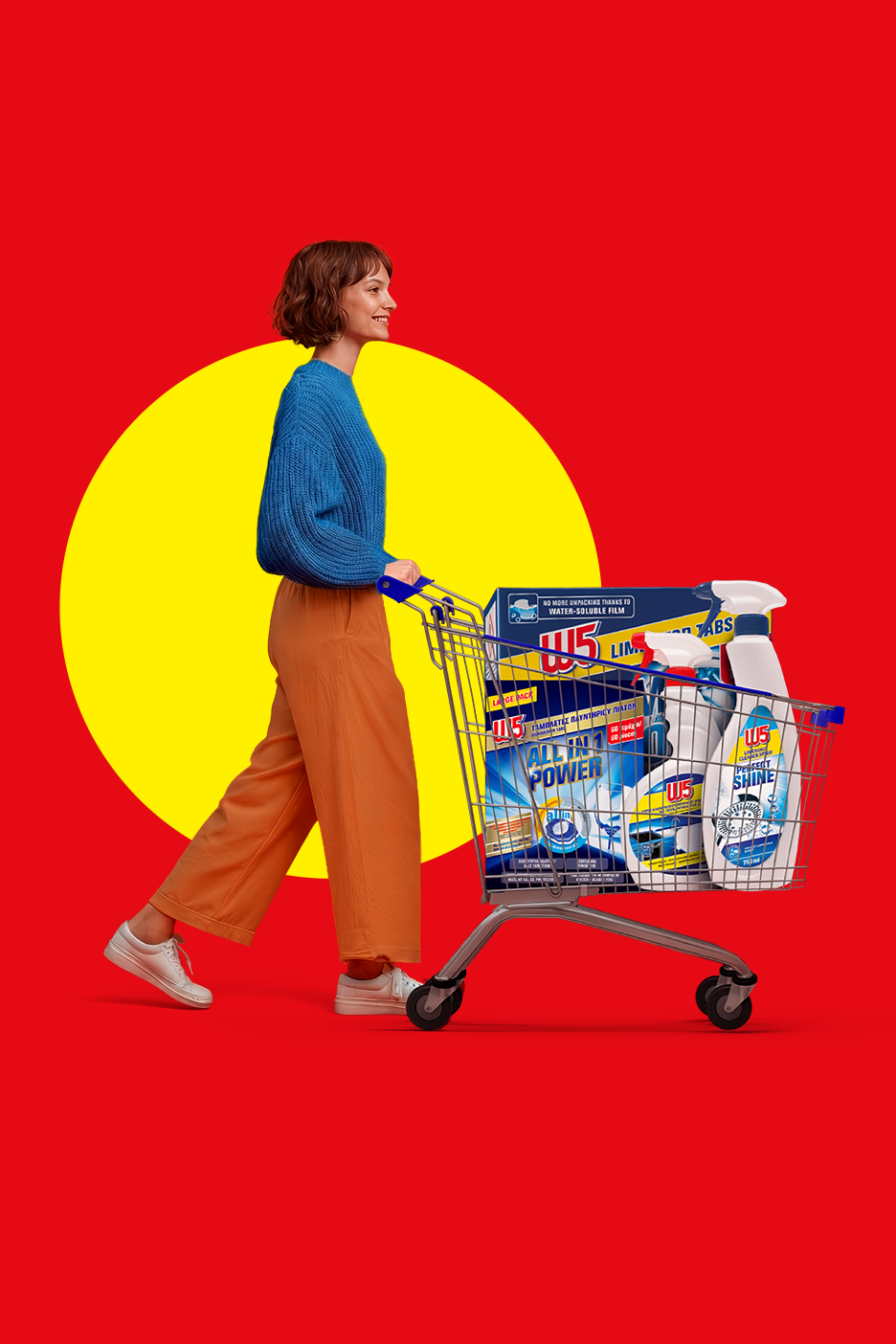Γυναίκα σπρώχνει ένα καρότσι γεμάτο με προϊόντα καθαρισμού W5, όπως ταμπλέτες πλυντηρίου πιάτων και σπρέι καθαρισμού.