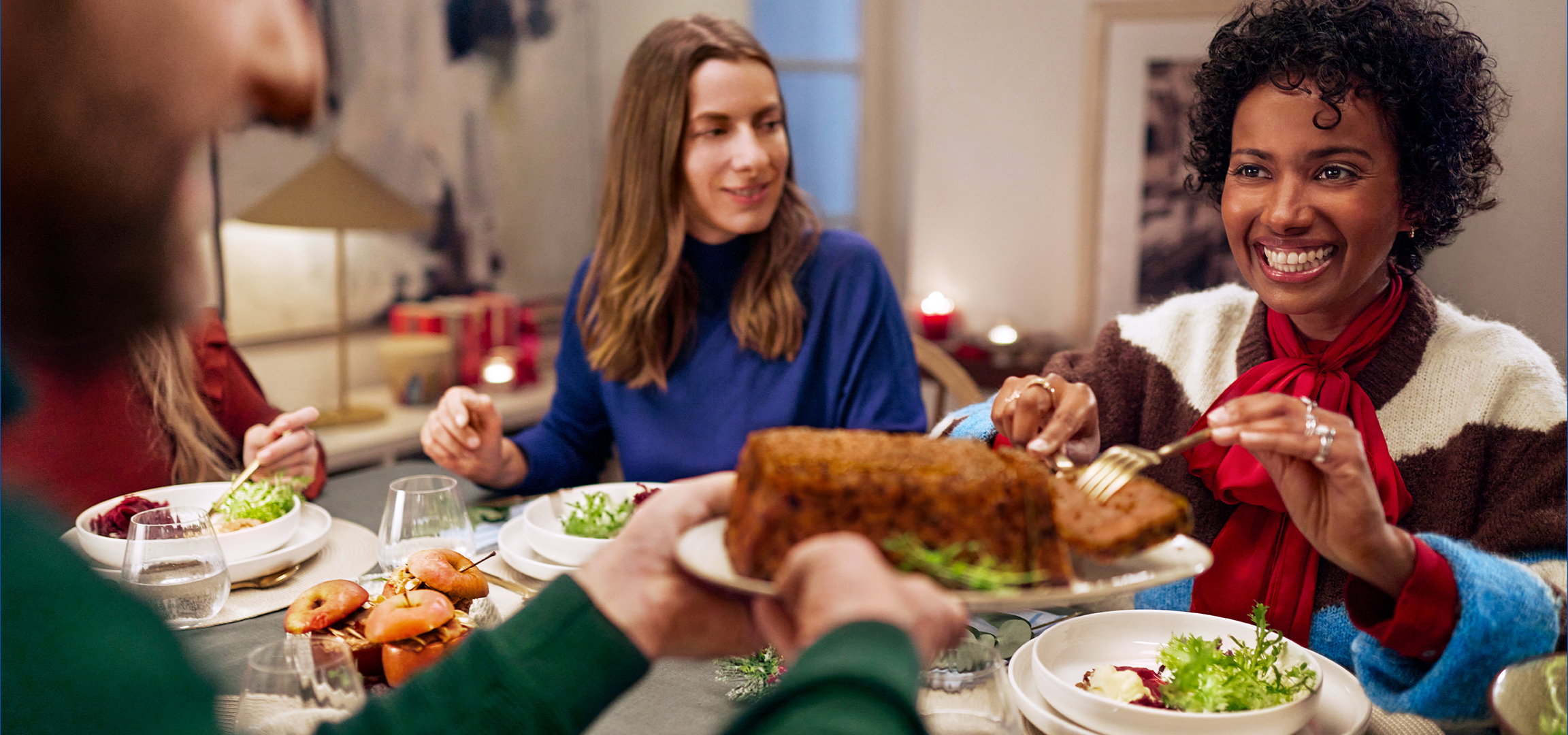 Οικογένεια γιορτάζει τα Χριστούγεννα με φαγητό και χριστουγεννιάτικο δέντρο.