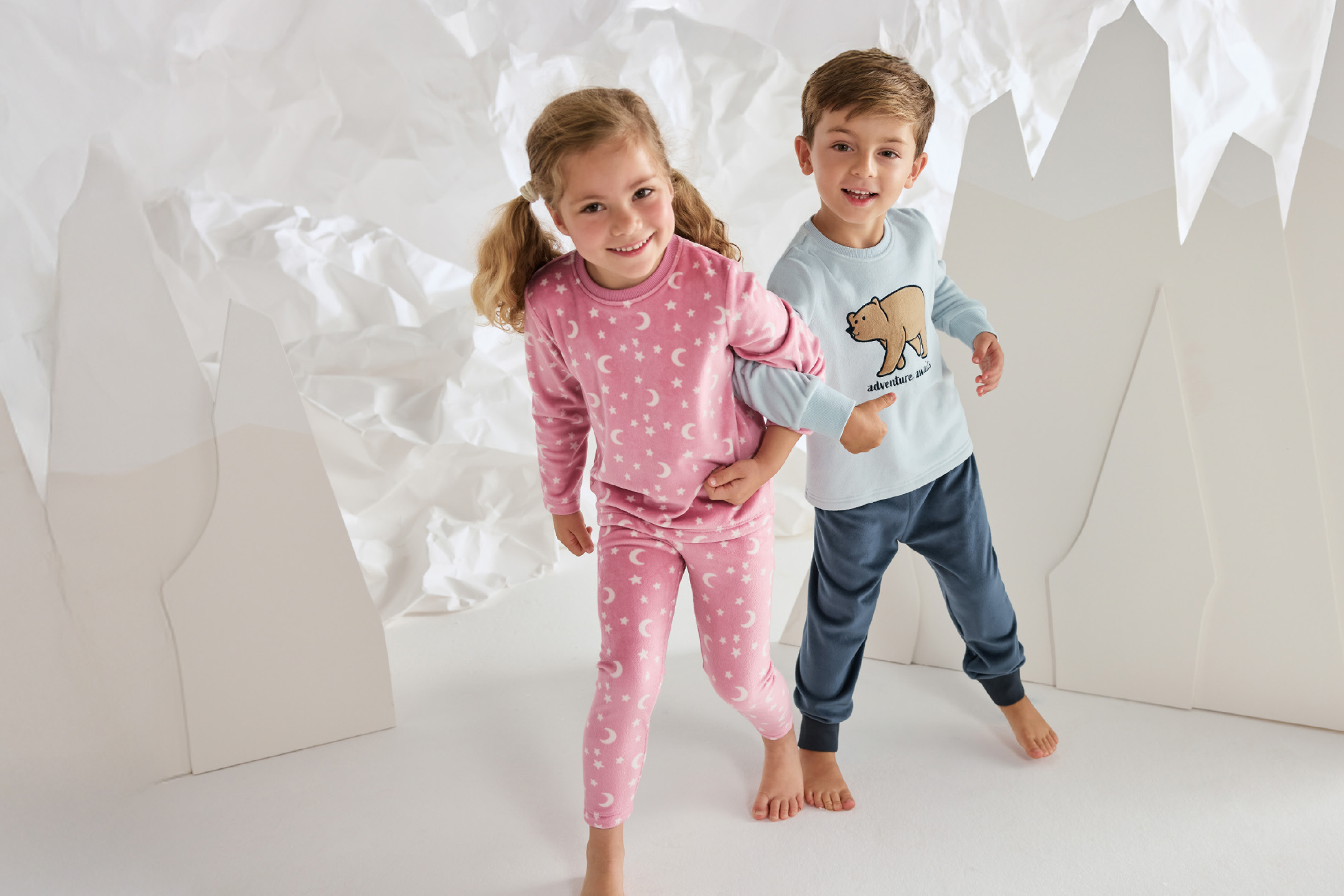 Παιδικές πιτζάμες με σχέδια αστεριών και φεγγαριών, σε ροζ και γαλάζιο χρώμα.