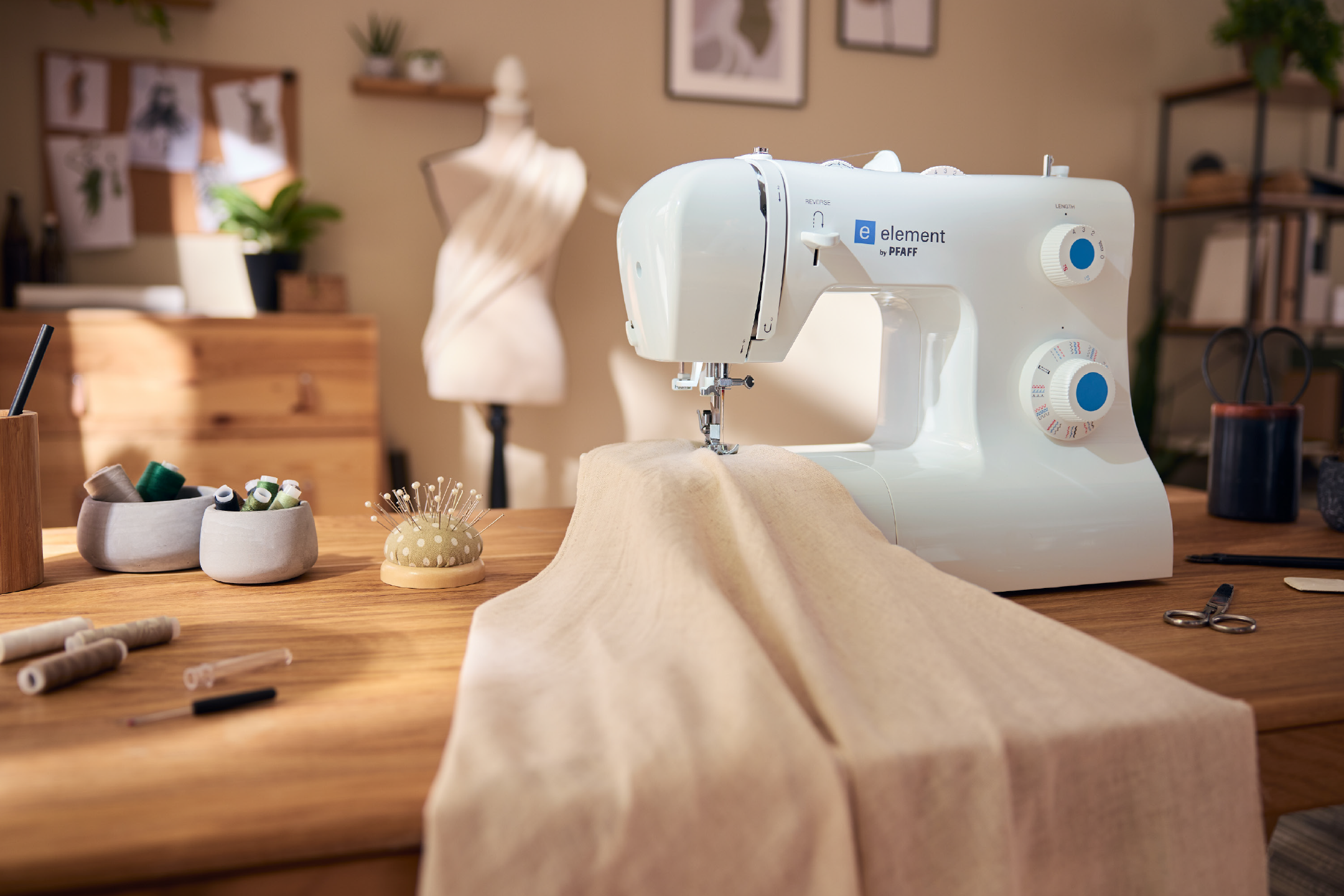 Ραπτομηχανή Pfaff Element σε ξύλινο τραπέζι με είδη ραπτικής και χειροτεχνίας.