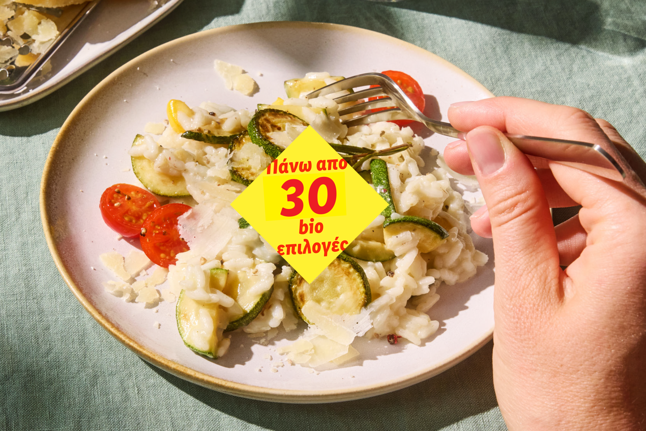 Ριζότο με κολοκυθάκια, ντοματίνια και τυρί, με την ένδειξη 'Πάνω από 30 βιο επιλογές'.