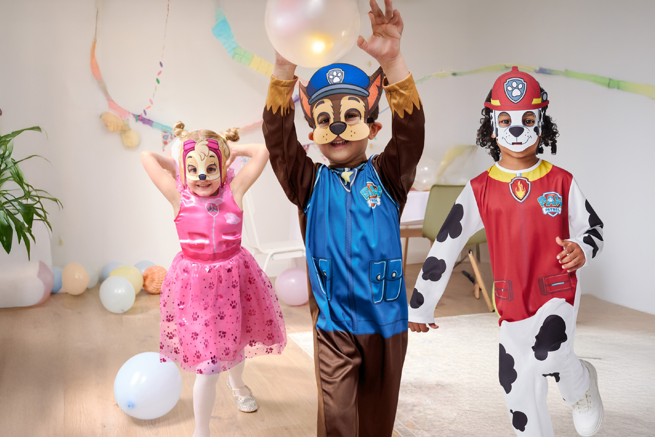 Παιδιά ντυμένα με στολές σκύλων, παίζουν με μπαλόνια σε ένα πάρτι.