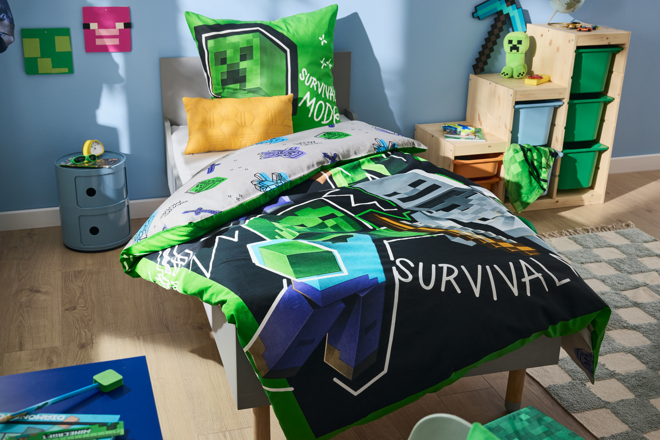Παιδικό δωμάτιο με κρεβάτι με παπλωματοθήκη και μαξιλάρια με θέμα Minecraft, και αποθηκευτικά έπιπλα.