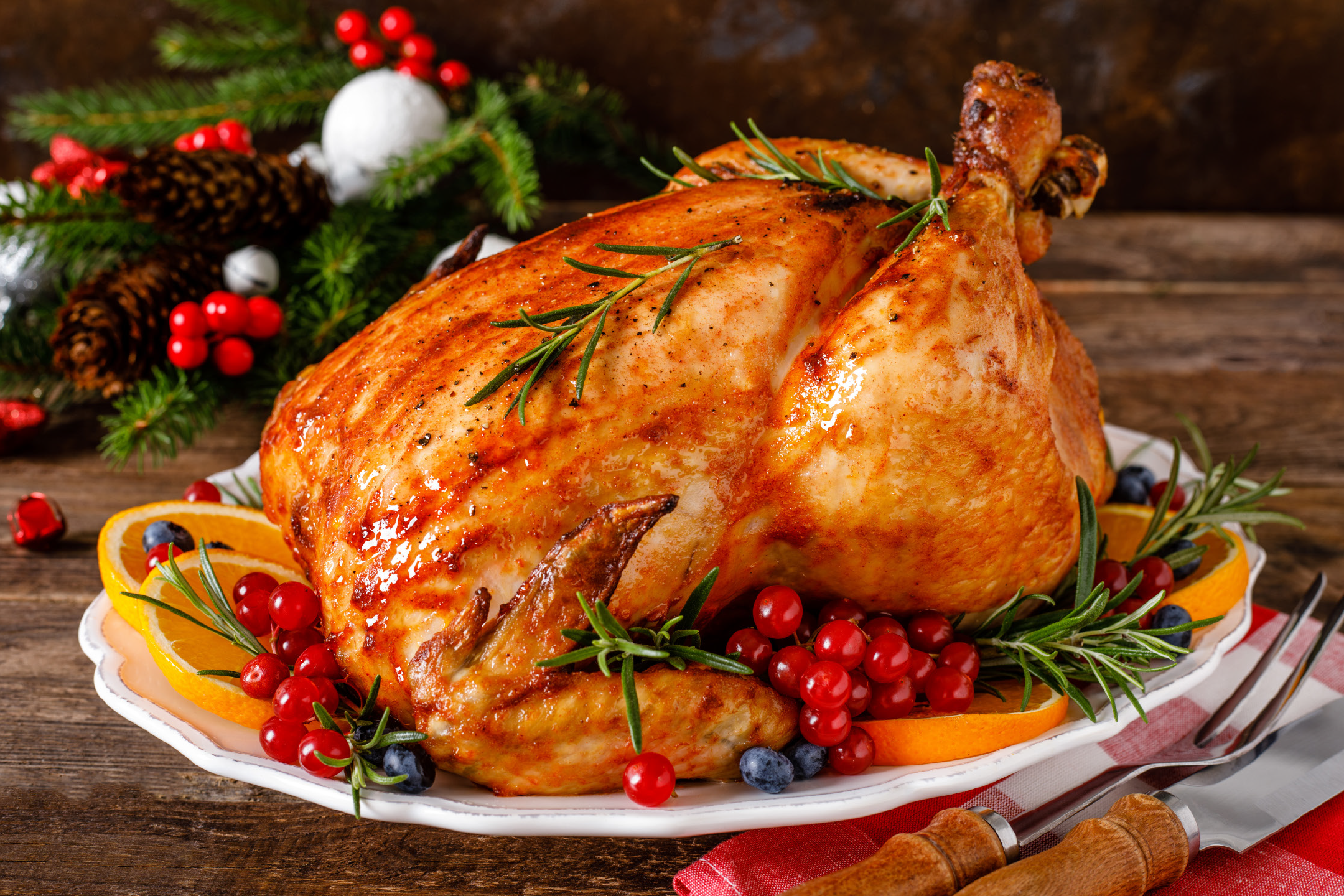 Ψητό κοτόπουλο με δεντρολίβανο, πορτοκάλια και κόκκινα μούρα, με χριστουγεννιάτικη διακόσμηση.